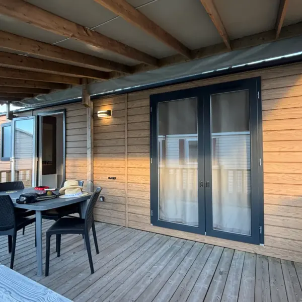 Terrasse en bois avec table et portes vitrées