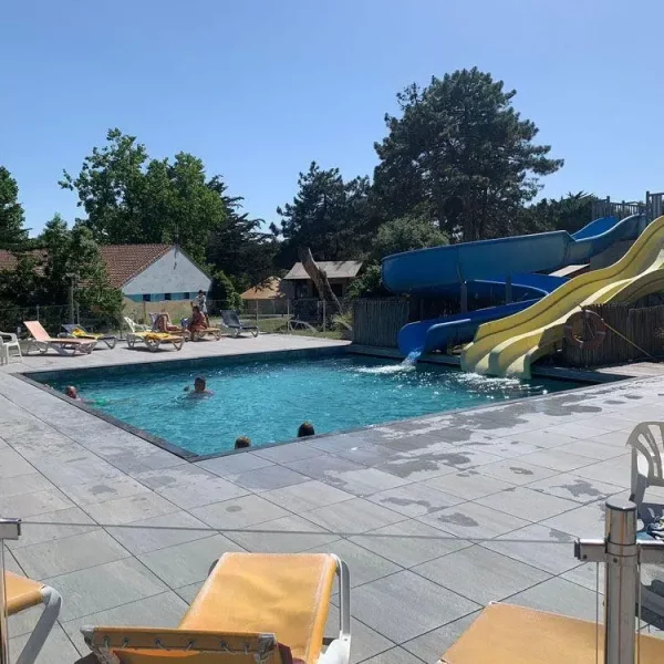 Piscine extérieure avec toboggans et transats ensoleillés