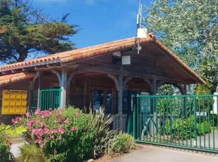 Petit bâtiment en bois avec portail vert