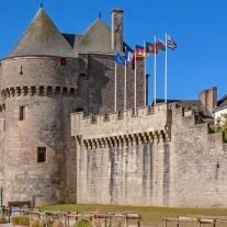 Château médiéval en pierre avec tours et drapeaux