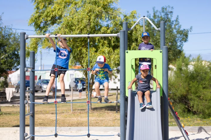 Enfants jouant sur structure de parc et toboggan