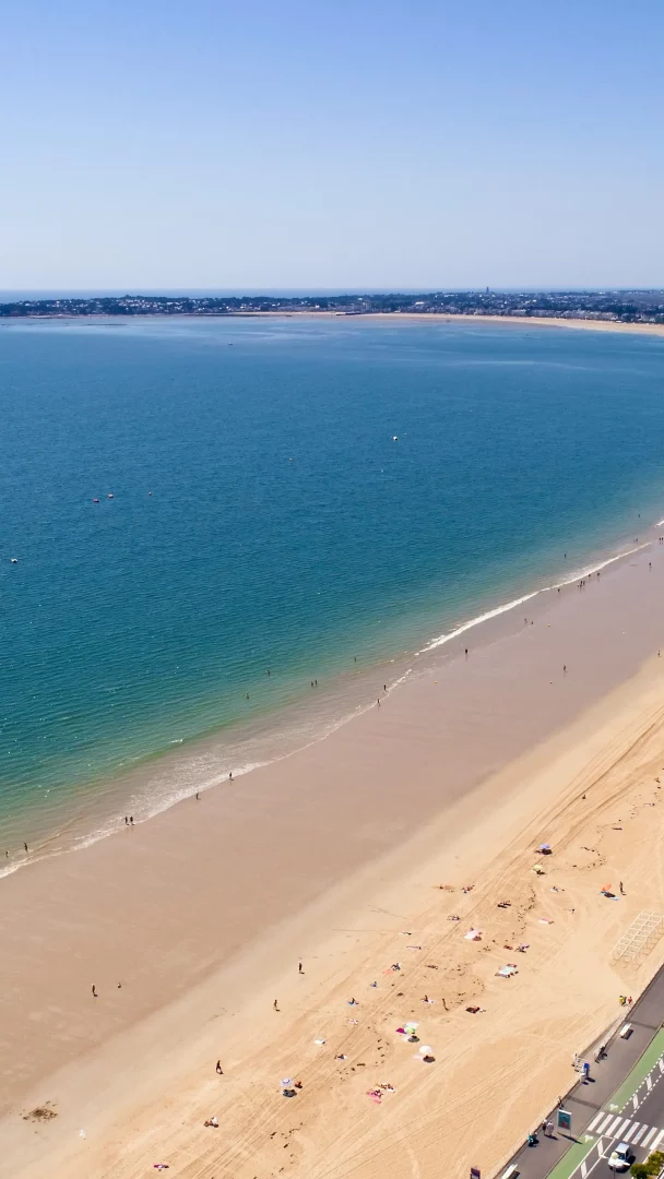 Vue aérienne d’une longue plage urbaine et océan