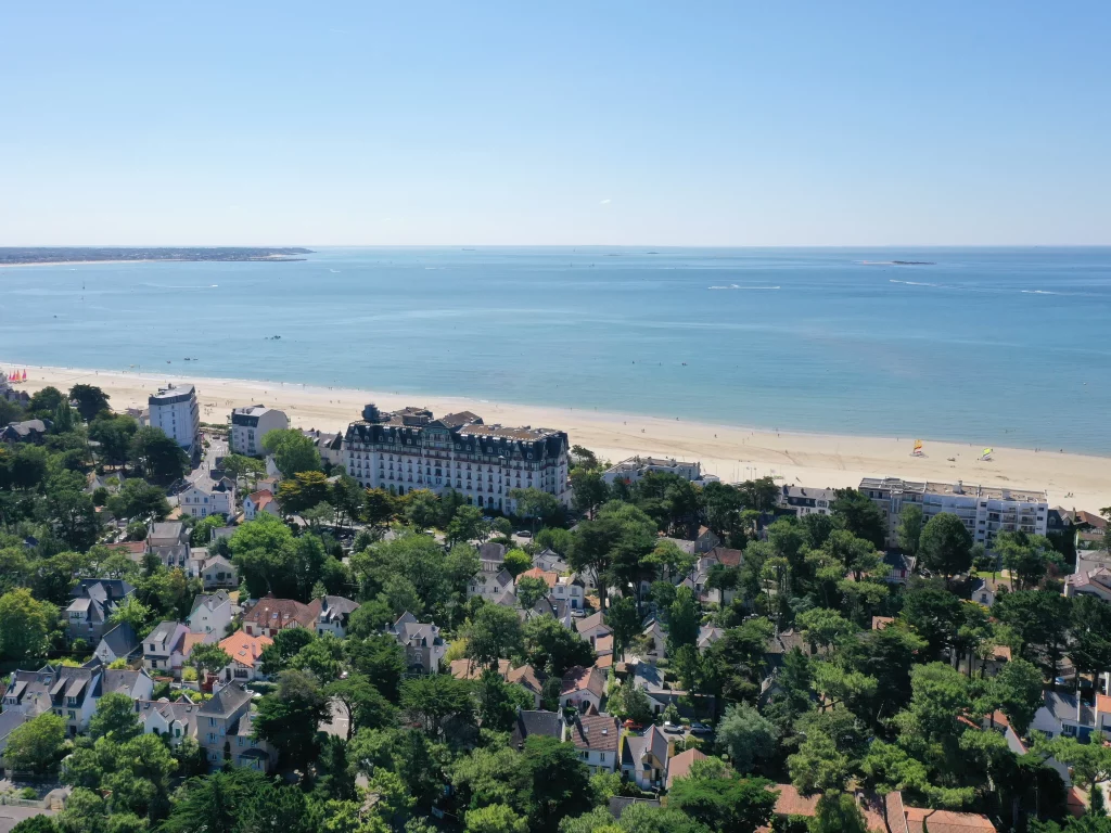 Vue aérienne station balnéaire plage océan maisons verdure
