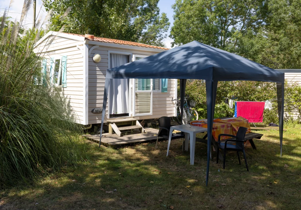 Mobil-home avec tonnelle et table de jardin