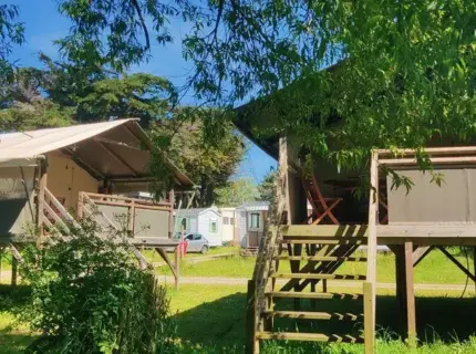 Tentes sur pilotis dans camping verdoyant