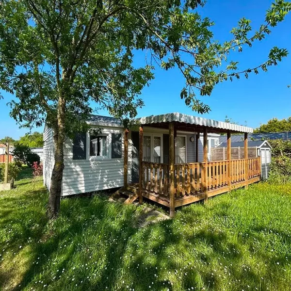 Mobil-home avec terrasse en bois et jardin verdoyant