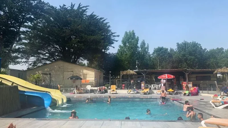 Piscine extérieure avec toboggan et familles en été