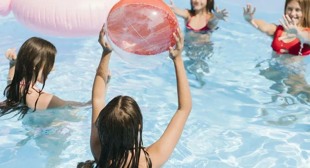 Enfants jouant au ballon dans une piscine