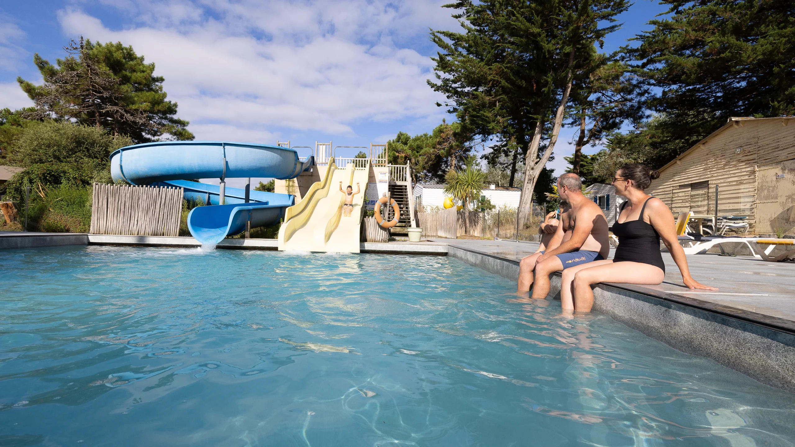 Famille à la piscine avec toboggans aquatiques
