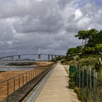 Promenade côtière avec pont et ciel nuageux