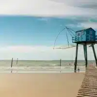 Cabane de pêche bleue sur pilotis au bord de mer