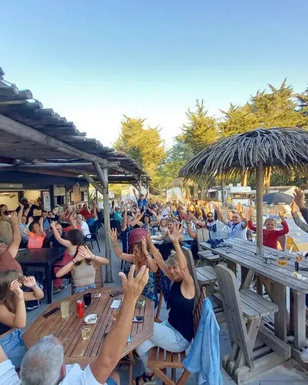 Terrasse animée avec clients levant les mains