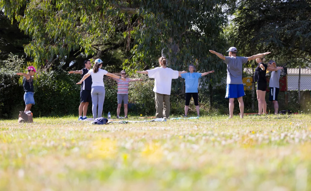 Groupe faisant exercices bras écartés dans un parc